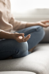 Meditation at home. Close up cropped vertical shot young woman sit on couch rest do yoga meditate...