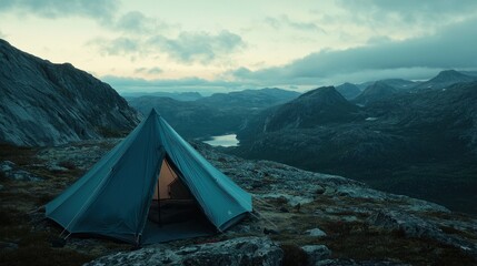 Mountaintop tent campsite overlooking serene valley at dusk.