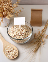 Flocons d'avoine dans un bol en verre avec &eacute;tiquette blanche et ingr&eacute;dients naturels