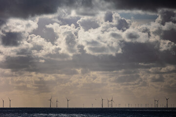 Dark clouds of a thunderstorm over silhouettes of wind turbines in the North sea