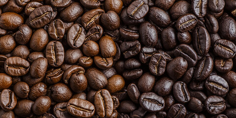 A close-up image of roasted coffee beans, showcasing a variety of shades from light to dark, highlighting their rich textures and natural sheen.