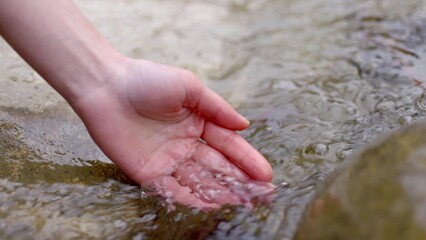 Collecting water from river into hand palm