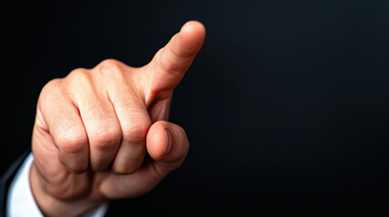 A close-up of a pointing hand against a dark background, symbolizing direction, authority, or emphasis in communication.