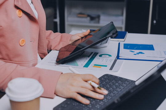 Cropped image of professional businesswoman working at her office via laptop, young female manager using portable computer device while sitting at modern loft, flare light, work process concept