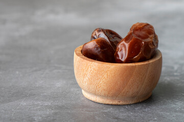 Three dates in a small wooden bowl. Popular during Ramadan as an Iftar Food.