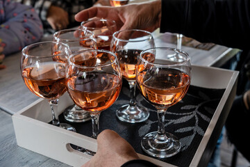 Rose wine tasting, glasses of rose wine on wood tray