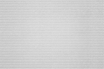 A textured white surface with horizontal linear patterns, resembling a ribbed fabric or material backdrop.