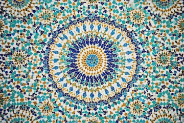 Intricate mosaic art with a mesmerizing radial pattern in shades of blue, turquoise, gold, and white.