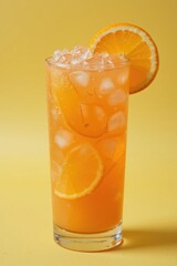Refreshing Orange Beverage with Ice and Slices in a Tall Glass Against a Vibrant Yellow Background