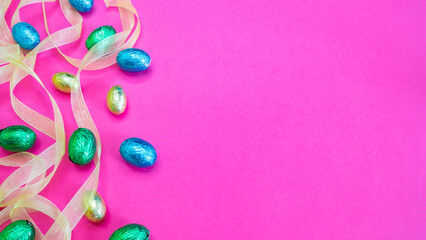 Huevos de Pascua coloridos y cinta sobre fondo rosa
