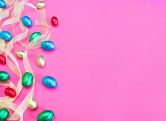 Huevos de Pascua coloridos y cinta sobre fondo rosa