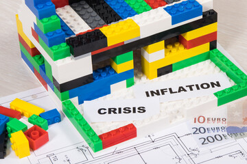 House under construction made of toy blocks, money, housing plan, inscription crisis and inflation. Rising costs of building or renovating home
