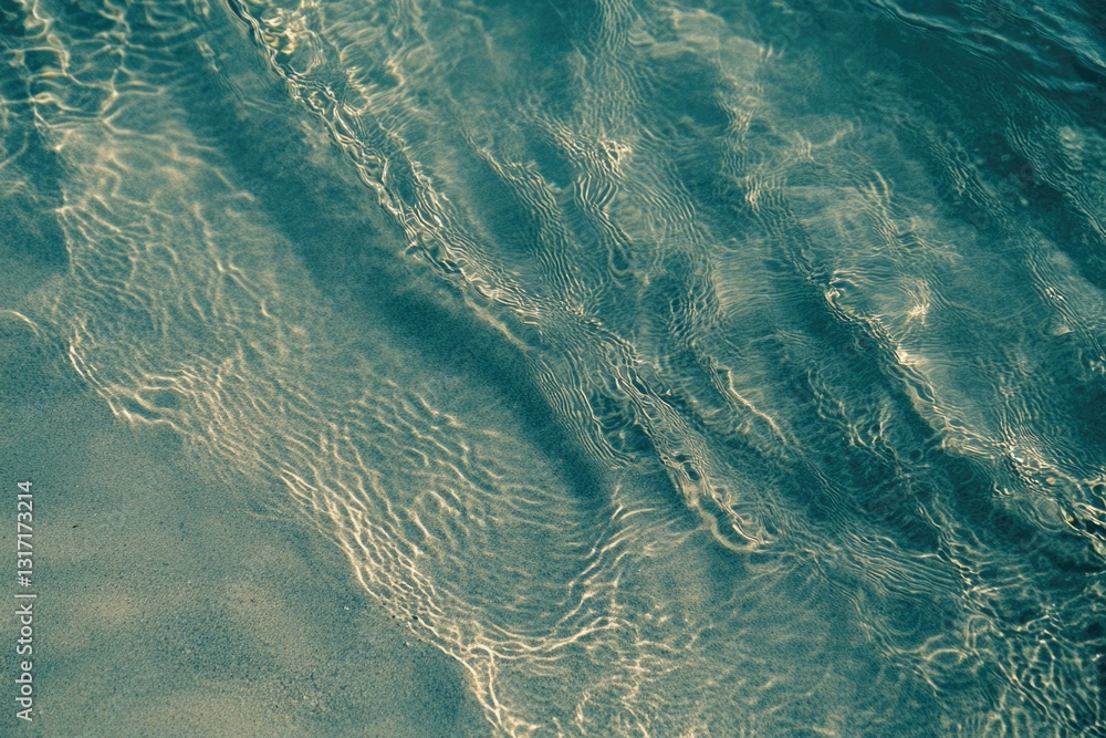 Poster shallow clear water flows over a sandy seabed, sunlight creating ripples and patterns.