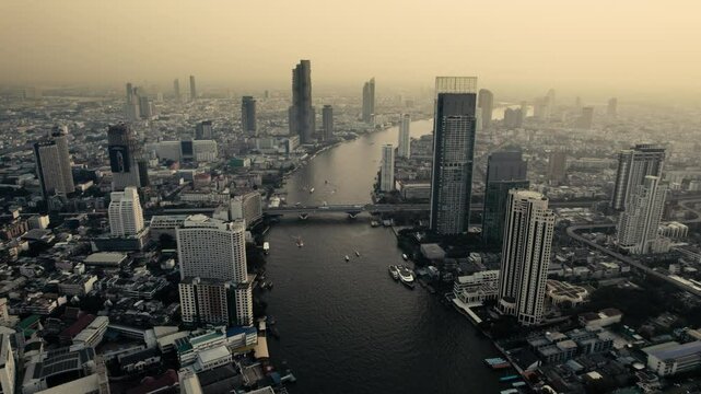 Sunset at Bangkok high aerial view of the Chao Phraya River at Si Lom districts at sunset. A large asian capital city with skyscrapers and millions of inhabitants. Beautiful Cinematic 4k footage 2025