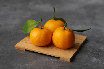 Delicious and fresh mandarin oranges on a gray background
