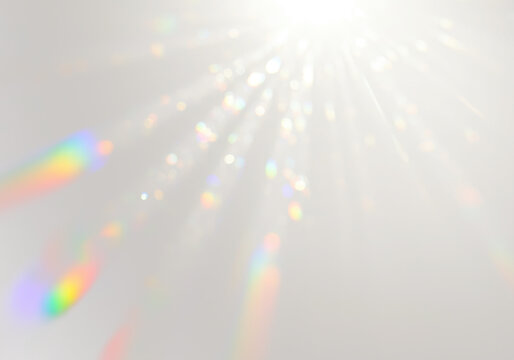 Ethereal light leak effect with bright white source casting diffused beams and spectral rainbow streaks, luminous glow on transparent background