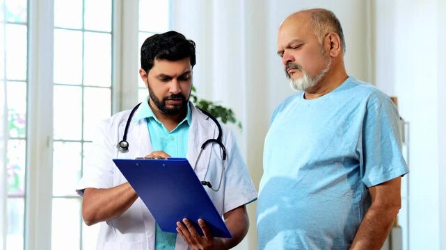 Indian Asian male doctor walks with a senior patient in a hospital passage, explaining the case report and procedure. He provides expert guidance, ensuring clarity, confidence, and quality healthcare