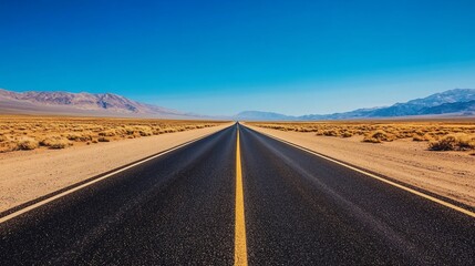 Fototapeta premium Endless Desert Highway: A Journey Through Arid Landscapes Under a Vast Blue Sky