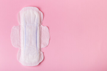Menstrual pad on pink background, top view.