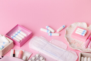 Menstrual tampons, hygiene pads on pink background, top view. Hygiene and protection products for women during menstruation. Women's health and menstrual cycle.
