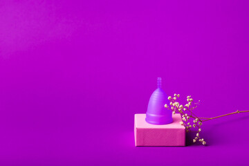 Menstrual cup to create protection during menstruation. Feminine hygiene concept. Women's health. Menstrual cup on violet background. Hygiene products for women.