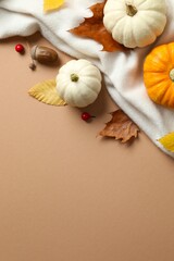 Beautiful autumn composition with pumpkins and leaves on soft beige scarf