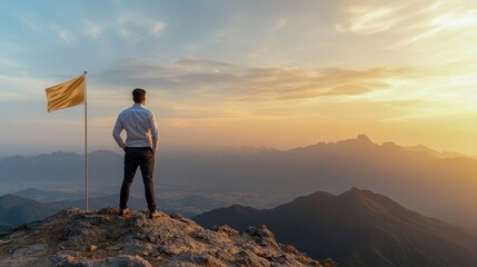 Man standing on a mountain peak with a flag at sunset.