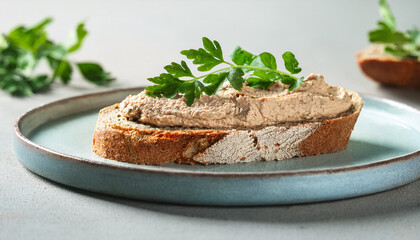 Crusty bread with smooth liver pate and fresh green herbs. Delicious lunch bite. Tasty snack.