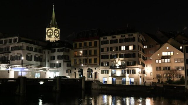 zurich's old town night scene includes river st peter's church illuminated skyline historic city panning view switzerland st. nighttime iconic landmarks cultural heritage 