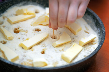 raw apple pie being prepared, showcasing the process of poking holes in the crust with a wooden toothpick for ventilation. Perfect for cooking and baking themes