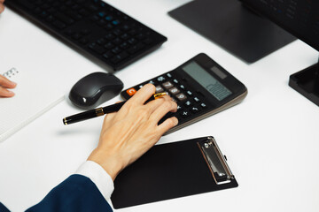 Cropped hands businessman with coworker calculating with calculator manual's financial and...