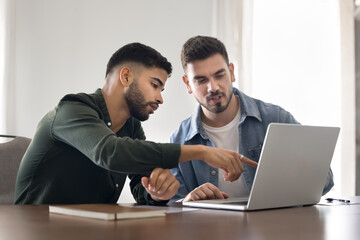 Professional man presenting idea or commercial offer to colleague or client pointing on laptop...