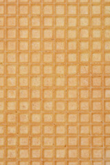 A close-up, full-frame shot of a wafer sheet texture, displaying its fine square grid pattern and light brown color