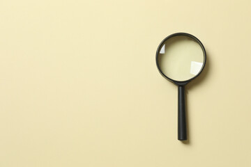 Magnifying glass on beige background