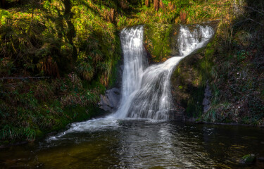 Autumn waterfall landscape. Waterfall cascade in autumn. Autumn forest waterfall