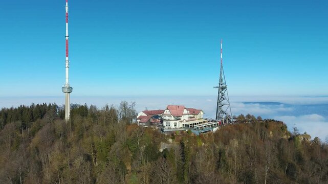 uetliberg mountain peak hotel restaurant communication tower overlooking zurich switzerland forest covered landscapes via upward aerial drone shot forested 