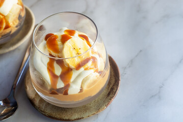 homemade no-bake banoffee pie cups on white table.