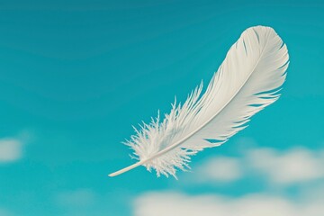 A single white feather floats gently in the blue sky