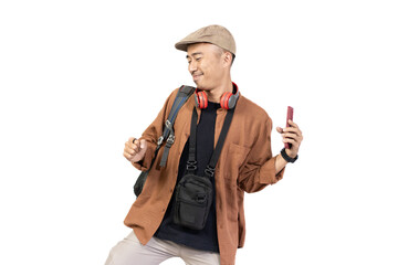 Young Indonesian male traveler happy and excited while listening to music from mobile phone while traveling, travel concept, isolated on white background.