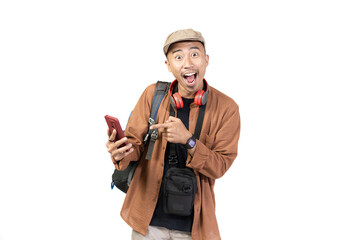 Happy young Indonesian male traveler pointing at mobile phone while traveling, travel concept, isolated on white background.