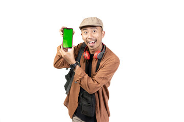young indonesian male traveler showing green mobile phone screen to camera, copy space and travel advertisement, travel concept, isolated on white background.