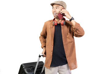 Young Indonesian male traveler is on voice call while carrying suitcase while traveling, travel...