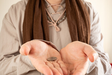 man in old peasant clothes begging with open palms