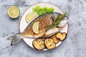 Plate with tasty grilled dorado fish on light background