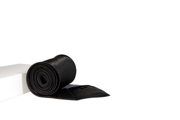 A black tie rolled on white background closeup shot 