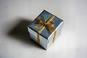 Gift box with gold ribbon sparkling silver wrapping perfect for special occasions birthday celebrations holidays christmas or anniversary presents stylish festive decoration box wrapped with shiny