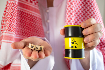 A man in a headscarf in Arab traditional clothing, holding a miniature oil barrel in a Gulf Arab...