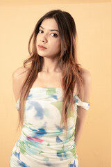 Obraz premium Elegant Young Woman in White Floral Summer Dress Posing Against White Background