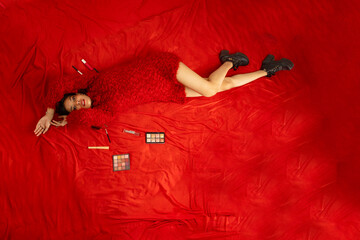 Top View of Stylish Young Woman in Red Dress on Furry Red Carpet Wearing Black Boots