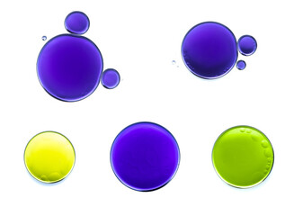 Set of bubbles and drops of water colored purple, yellow and green on a white background. Scientific experiment in chemistry.	